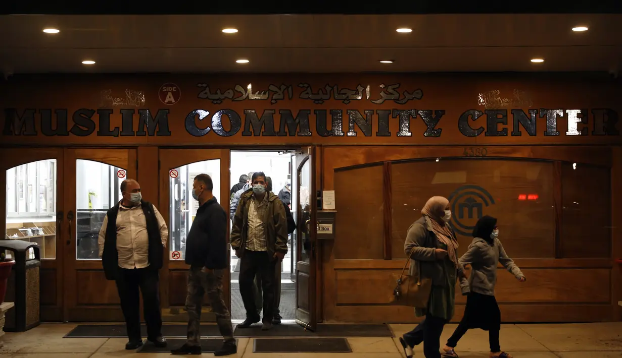 Umat Muslim keluar  setelah melaksanakan sholat malam yang disebut "tarawih" pada malam pertama bulan suci Ramadhan di Pusat Komunitas Muslim Chicago, Senin (13/4/2021). (AP Photo/Shafkat Anowar)