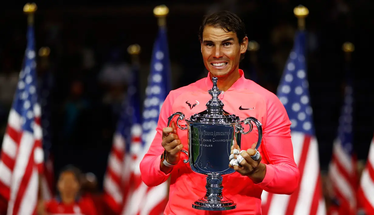Petenis Spanyol, Rafael Nadal memegang trofi AS Terbuka 2017 setelah mengalahkan petenis Afrika Selatan, Kevin Anderson di New York, Minggu (10/9). Bagi Nadal, ini adalah gelar ketiganya di AS Terbuka setelah 2010 dan 2013. (AP Photo/Julio Cortez)