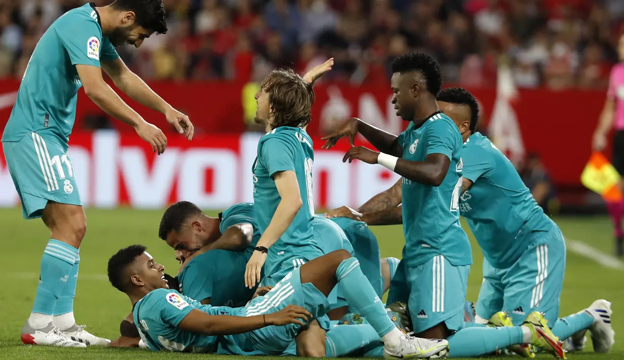 Penyerang Real Madrid Karim Benzema berselebrasi dnegan timnya setelah mencetak gol ke gawang Sevilla pada lanjutan Liga Spanyol di stadion Ramon Sanchez Pizjuan, Senin (18/4/2022) dini hari WIB. Real Madrid sukses menaklukkan Sevilla 3-2. (AP Photo/Angel Fernandez)