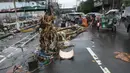 Pengendara kendaraan bermotor melewati batang pohon yang tergeletak di salah satu jalan di Manila, Filipina pada 25 Juli 2024. (TED ALJIBE/AFP)