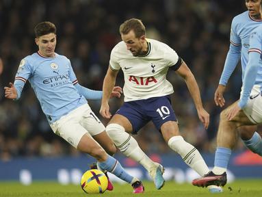Pemain Tottenham Hotspur, Harry Kane, berusaha melewati pemain Manchester City pada laga Liga Inggris di Stadion Etihad, Kamis (19/1/2023). (AP Photo/Dave Thompson)