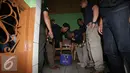 Petugas menumakan botol miras di salah satu caefe di kawasan kalijodo, Jakarta, Sabtu (20/2/2016). Polda Metro Jaya bersama TNI serta Satpol PP, Operasi penyakit masyarakat di kawasan kalijodo. (Liputan6.com/Herman Zakharia)