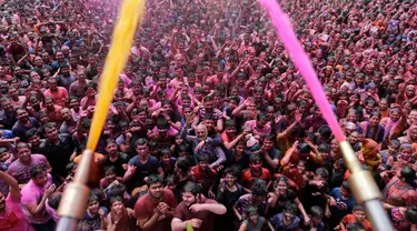 Umat Hindu bersorak ketika bubuk berwarna dan air disemprotkan kepada mereka saat Festival Holi di Kuil Swaminarayan, Ahmedabad, India, Selasa (10/3/2020). Festival Holi menandai datangnya musim semi di India. (AP Photo/Ajit Solanki)