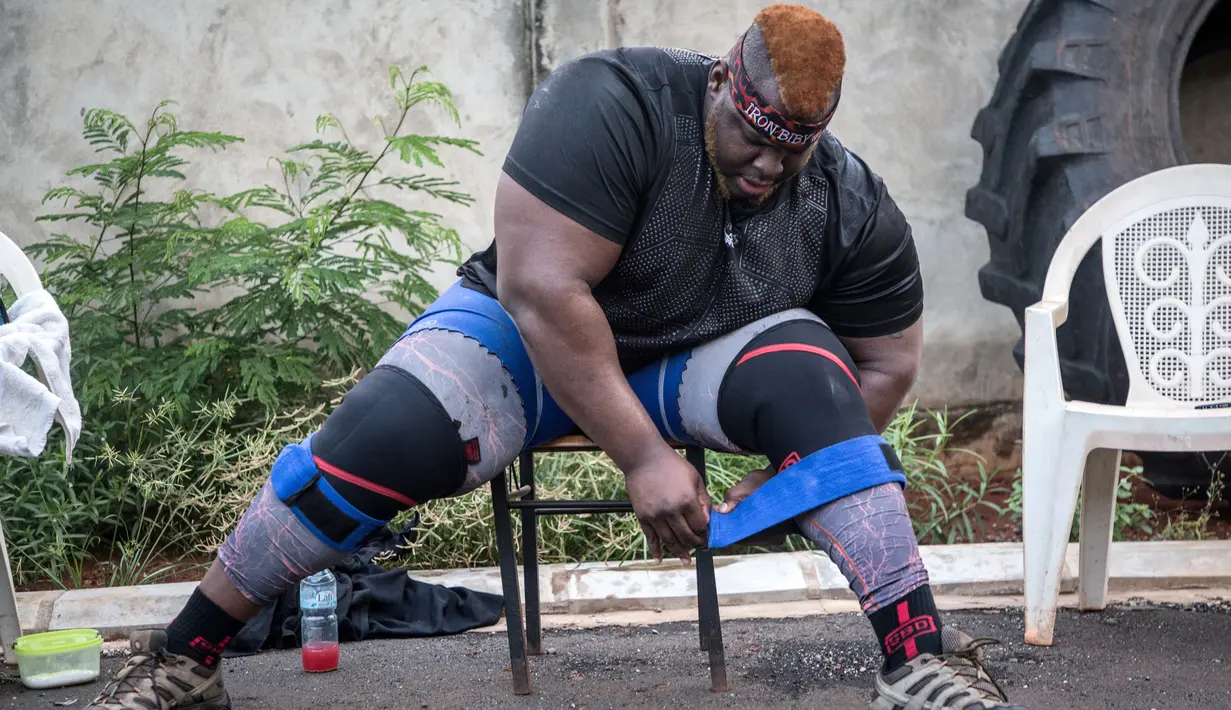 Iron Biby melakukan latihan di rumahnya di Bobo-Dioulasso, Burkina Faso pada 24 September 2018. Iron Biby berhasil memecahkan rekor mengangkat seorang wanita seberat 60 kilogram dengan 69 repetisi dalam waktu satu menit. (OLYMPIA DE MAISMONT / AFP)