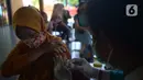 Petugas kesehatan menyuntikkan vaksin dosis ketiga (Booster) di RPTRA Kopi Gandaria, Pasar Rebo, Jakarta, Jumat (15/7/2022). Pemerintah Indonesia mewajibkan vaksinasi booster sebagai persyaratan untuk memasuki fasilitas publik/fasilitas umum antara lain perkantoran, tempat wisata, pusat perbelanjaan, dan area publik.  (merdeka.com/Imam Buhori)