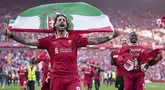 Pemain Liverpool, Dominik Szoboszlai melakukan selebrasi dengan membawa bendera Hungaria setelah membawa timnya memastikan gelar juara Liga Inggris 2024/2025 di Anfield, Liverpool, Inggris, Minggu (27/04/2025) waktu setempat. (AP Photo/Jon Super)
