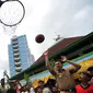 Gubernur DKI Jakarta Basuki T Purnama saat menjajal memasukkan bola ke dalam ring basket seusai meresmikan Ruang Publik Terpadu Ramah Anak (RPTRA) Intiland Teduh, Karet Tengsin, Jakarta, Rabu (30/12). (Liputan6.com/Yoppy Renato)