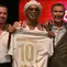 Pemain sepak bola asal Brasil yang baru direkrut, Ronaldinho, berpose di atas panggung mengenakan seragam Ravenna FC bersama presiden klub, Ignazio Cipriani (kanan), dalam acara presentasi tim di Marina di Ravenna pada 20 Agustus 2026. Ronaldinho, mantan pemenang Ballon d'Or dan Piala Dunia, akan kembali dari masa pensiunnya pada usia 46 tahun untuk bermain bagi Ravenna di kompetisi kasta ketiga Italia. (Stefano RELLANDINI/AFP)