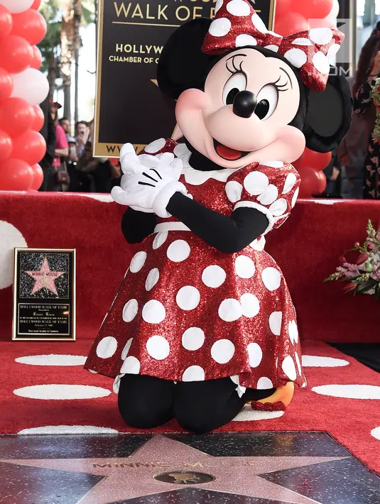 Kartun Disney, Minnie Mouse berpose dekat bintang Hollywood Walk of Fame miliknya saat acara penghargaan di Los Angeles, Senin (22/1). Bintang yang mengukir nama Minnie adalah yang ke-2.627 di Hollywood Walk of Fame. (Richard Shotwell/Invision/AP)