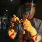 Pekerja medis berpakaian pelindung menulis pada sebuah tabung setelah mengumpulkan sampel untuk tes asam nukleat dari pasien yang diduga terinfeksi virus corona di hotel yang digunakan dalam isolasi medis virus corona di Wuhan, Provinsi Hubei, China, Selasa (4/2/2020). (Chinatopix via AP)