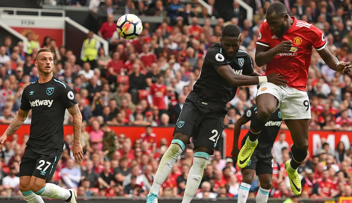 Penyerang MU, Romelu Lukaku saat menyundul bola dari kawalan pemain West Ham pada pertandingan Liga Inggris di Old Trafford, Manchester, Inggris, (13/8). MU menang telak atas West Ham dengan skor 4-0. (AFP Photo/Oli Scarff)