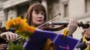 Anggota orkestra bermain sebagai bagian dari demonstrasi anti-perang menyusul serangan Rusia terhadap Ukraina di Trafalgar Square, London, Minggu (6/3/2022).  Flashmob yang terdiri dari 200 musisi klasik itu untuk menunjukkan dukungan terhadap Ukraina setelah invasi Rusia. (AP Photo/Alberto Pezzali)