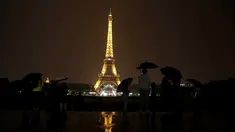 Sejumlah wisatawan menikmati pemandangan Menara Eiffel yang diterangi lampu dari Trocadero Plaza di Paris, Prancis (1/9).( AFP Photo/Ludovic Marin)