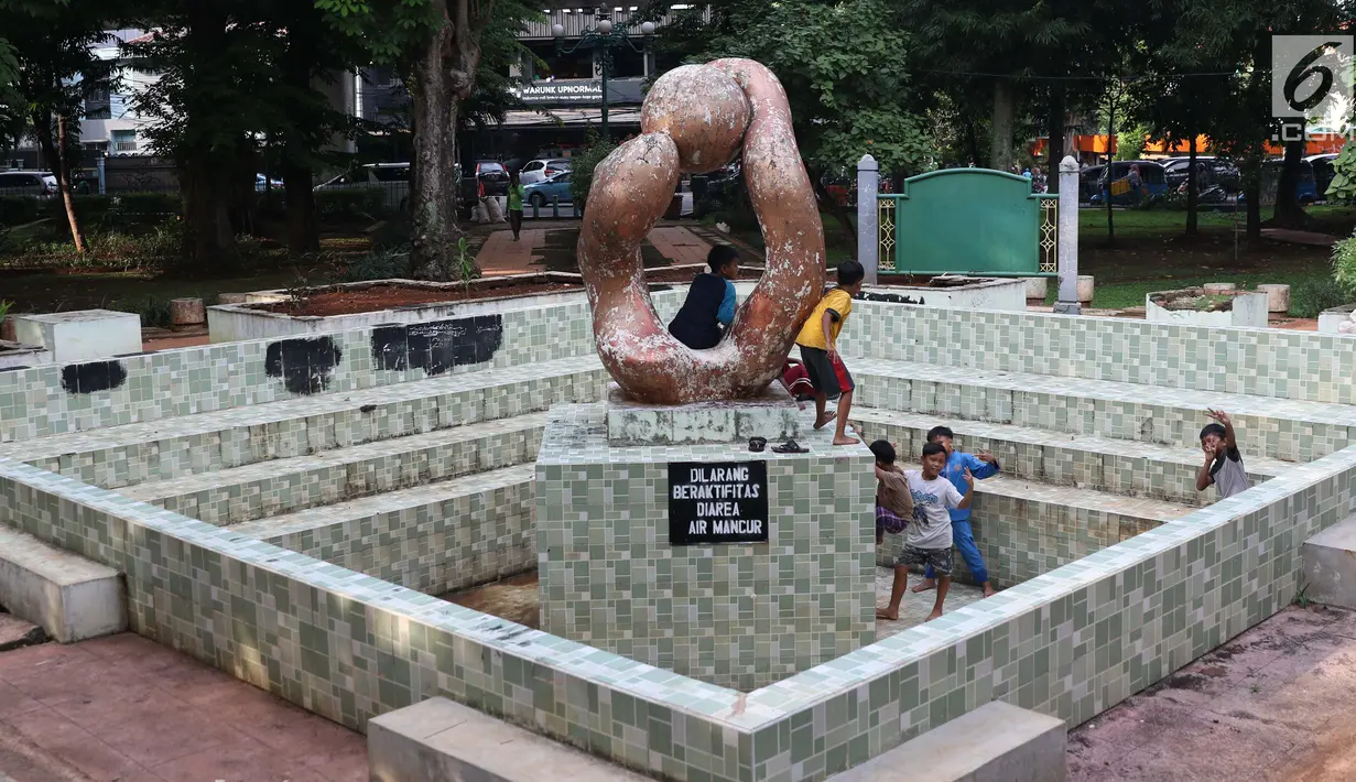 Anak-anak bermain di kolam air mancur di area Taman Puring , Jakarta, Jumat (11/1). Tahun 2019, Pemprov DKI Jakarta berencana merevitalisasi lima taman, salah satunya Taman Puring di Jakarta Selatan. (Liputan6.com/Helmi Fithriansyah)