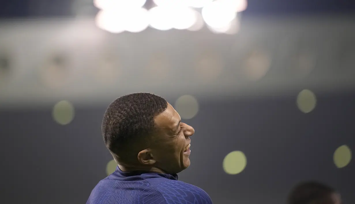 Penyerang Prancis, Kylian Mbappe tertawa selama sesi latihan di stadion Jassim Bin Hamad di Doha, Qatar, Jumat (16/12/2022). Prancis akan melawan Argentina pada pertandingan final Piala Dunia 2022 di Lusail Iconic Stadium, Minggu (18/12/2022). (AP Photo/Christophe Ena)