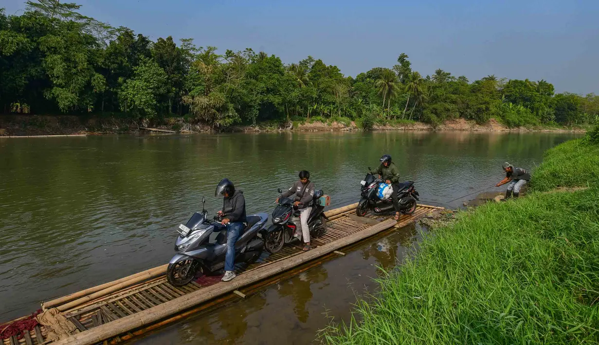 Warga bersama sepeda motornya menyeberangi Sungai Cisadane menggunakan rakit bambu di kawasan Ciseeng, Kabupaten Bogor, Jawa Barat, Kamis (11/6/2026). (merdeka.com/Arie Basuki)