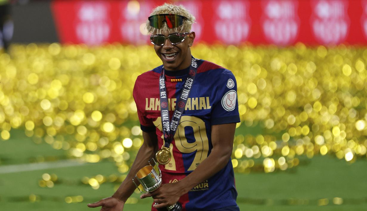 Pemain Barcelona, Lamine Yamal merayakan kemenangan setelah timnya mengalahkan Real Madrid dalam laga final Copa Del Rey di La Cartuja stadium, Sevilla, Spanyol. (AP Photo/Joan Monfort)