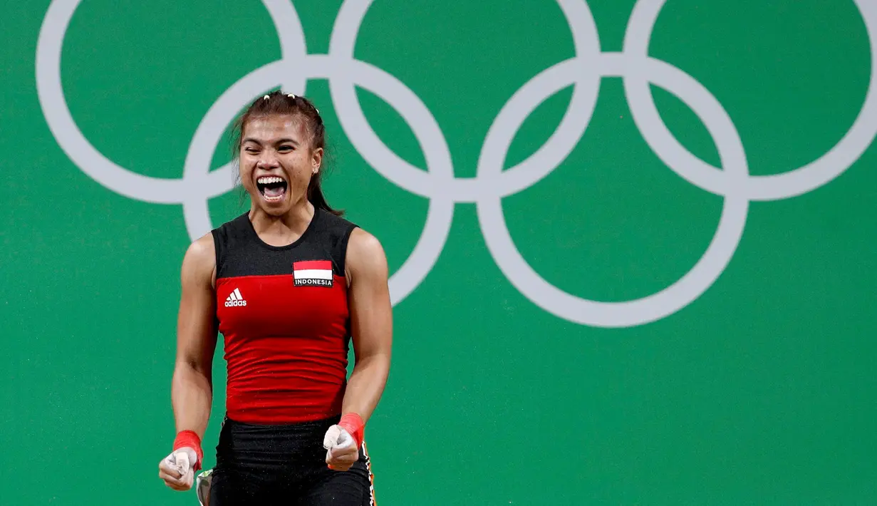 Ekspresi Sri Wahyuni Agustiani saat berhasil mengangkat beban di kelas 48 kilogram pada Olimpiade 2016, Brasil, Minggu (7/8). Sri menyumbang medali perak untuk Indonesia setelah sukses mengangkat beban dengan total 192 kilogram. (REUTERS)