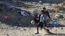 Sejumlah anak Palestina bermain sepak bola di kawasan Gaza, Jumat (3/11/2017). Sepak bola tidak hanya menjadi olahraga favorit, tapi juga sebagai salah satu cara bagi warga untuk mengurangi ketegangan akibat peperangan. (AFP/Mohammed Abed)