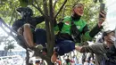 Dua warga memanjat pohon di depan Hotel Kempinski saat mengabadikan parade pembalap MotoGP, Moto2, Moto3, ATC, dan klub motor dari Istana Merdeka hingga Hotel Kempinski di Bundaran HI Jakarta Pusat, Rabu (16/03/2022). (Bola.com/Bagaskara Lazuardi)