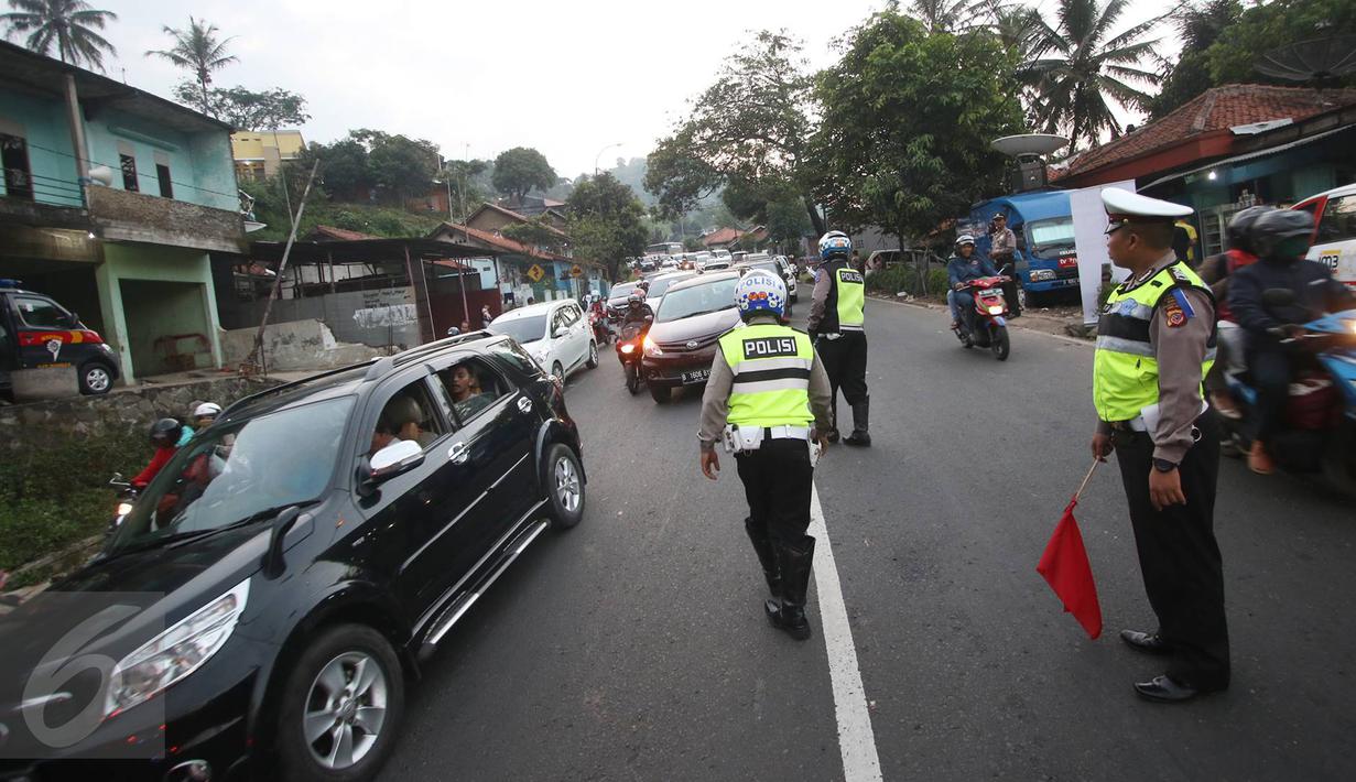 Petugas kepolisian mengatur arus lalu lintas di Simpang Nagreg, Jawa Barat, Sabtu (2/7). Polisi memberlakukan sistem rekayasa lalu lintas untuk menghindari kemacetan yang menuju ke Garut dan Tasik. (Liputan6.com/Immanuel Antonius)