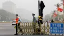 Petugas menutup jalur sepeda dekat Lapangan Tiananmen saat badai debu menerjang kota Beijing, China, Kamis (4/5). Badai debu menyebabkan warga harus menutupi mulut dan hidung mereka dengan masker dan bandana. (AP Photo/Andy Wong)