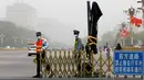 Petugas menutup jalur sepeda dekat Lapangan Tiananmen saat badai debu menerjang kota Beijing, China, Kamis (4/5). Badai debu menyebabkan warga harus menutupi mulut dan hidung mereka dengan masker dan bandana. (AP Photo/Andy Wong)