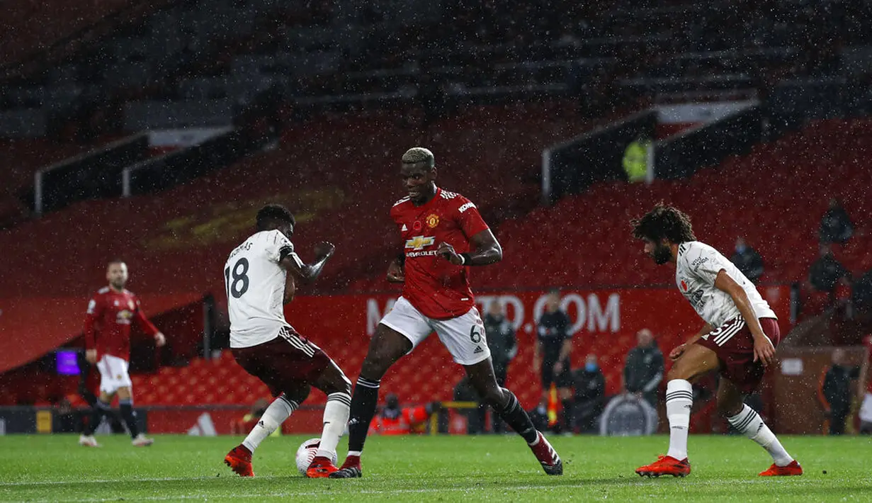 Pemain Manchester United Paul Pogba (tengah) berebut bola dengan pemain Arsenal Thomas Partey (kiri) dan Mohamed Elneny pada pertandingan Liga Premier Inggris di Stadion Old Trafford, Manchester, Inggris, Minggu (1/11/2020). Arsenal menang 2-0. (Phil Noble/Pool via AP)