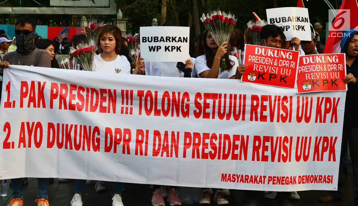 Massa membentangkan spanduk dalam aksi meminta revisi UU KPK di depan Istana, Jakarta, Jumat (13/9/2019). Dalam aksinya, mereka juga mendukung keberadaan Dewan Pengawas KPK agar KPK tetap independen dan bebas dari intervensi politik. (Liputan6.com/Johan Tallo)