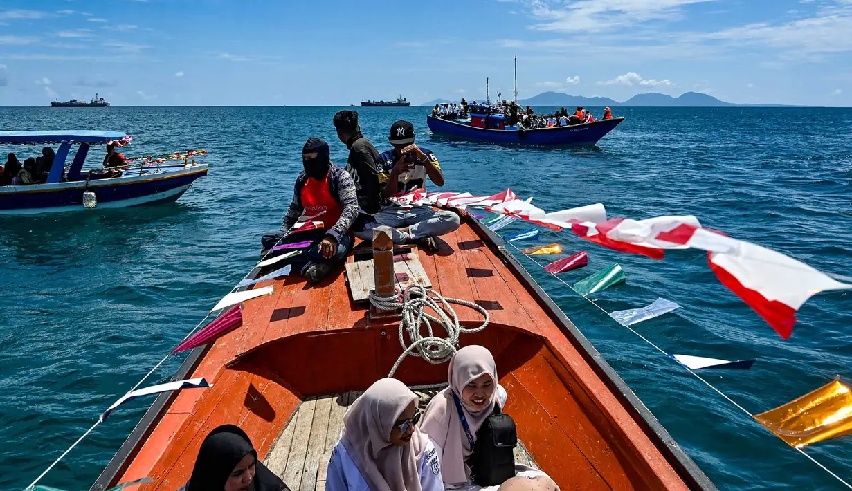 Nelayan yang tergabung dalam wilayah Panglima Laot Lok Kuala Cangkoi bersama warga mengikuti pawai kapal hias pada tradisi kenduri laut di Ulee Lheu, Banda Aceh, Aceh, Rabu (22/7/2026). (AFP/ Chaideer Mahyuddin)