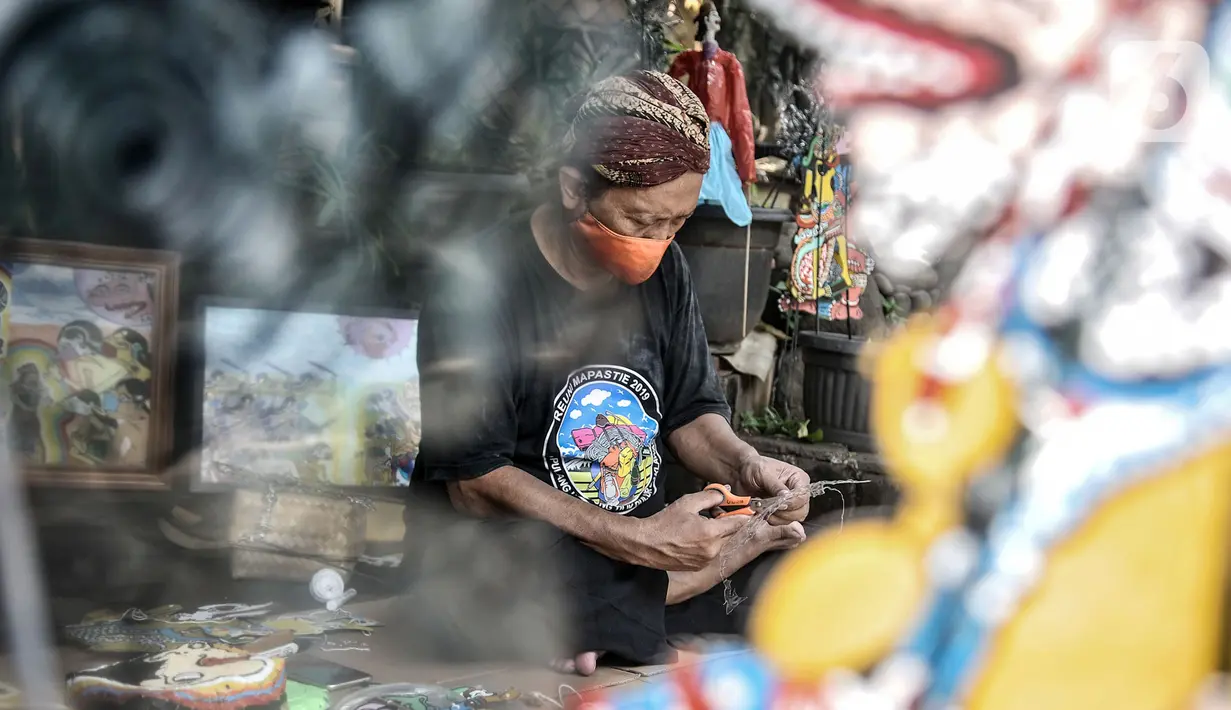Seniman Iskandar Hardjodimuljo menyelesaikan pembuatan wayang uwuh di kawasan Cawang, Jakarta, Kamis (29/10/2020). Wayang uwuh terbuat dari limbah rumah tangga seperti kardus dan plastik. (merdeka.com/Iqbal S. Nugroho)