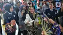 Calon penumpang memotret para prami, prama, dan kondektur PT. KAI yang melakukan catwalk untuk memperkenalkan seragam baru di Stasiun Gambir, Jakarta Pusat, Kamis (22/12/2022). Acara ini sekaligus menghibur para penumpang yang tengah menunggu keberangkatan kereta api. (Liputan6.com/Angga Yuniar)