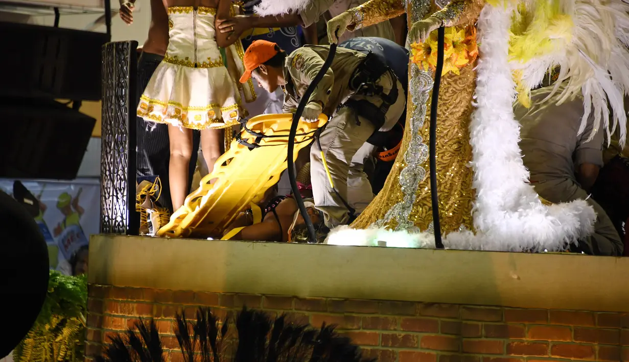 Petugas pemadam kebakaran mengevakuasi korban dari sekolah samba Unidos da Tijuca saat Rio Carnival di Rio de Janeiro, Brasil (28/2). (AFP PHOTO/Vanderlei Almeida)