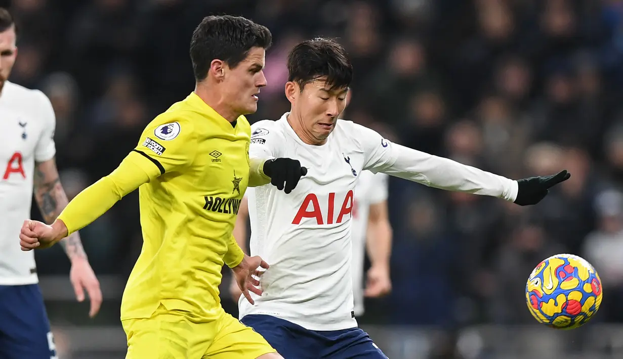 Gelandang Brentford Christian Norgaard (tengah) berebut bola striker Tottenham Hotspur Son Heung-Min dalam lanjutan Premier League di Tottenham Hotspur Stadium, Jumat (3/12/2021) dini hari WIB. Tottenham Hotspur berhasil mengalahkan Brentford dengan skor 2-0. (Daniel LEAL/AFP)
