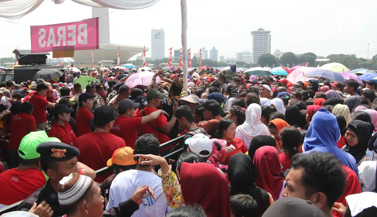 Warga antre untuk mendapatkan sembako gratis dalam acara "Untukmu Indonesia" di lapangan Monas, Jakarta, Sabtu (28/4). Acara "Untukmu Indonesia" digelar oleh Forum Untukmu Indonesia. (Liputan6.com/Arya Manggala)