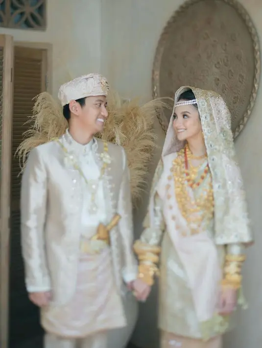 Uni dan Uda, pasangan ini berpose mesra sambil tebar senyuman dengan baju bernuansa gold. (Instagram/sabrinaanggraini).