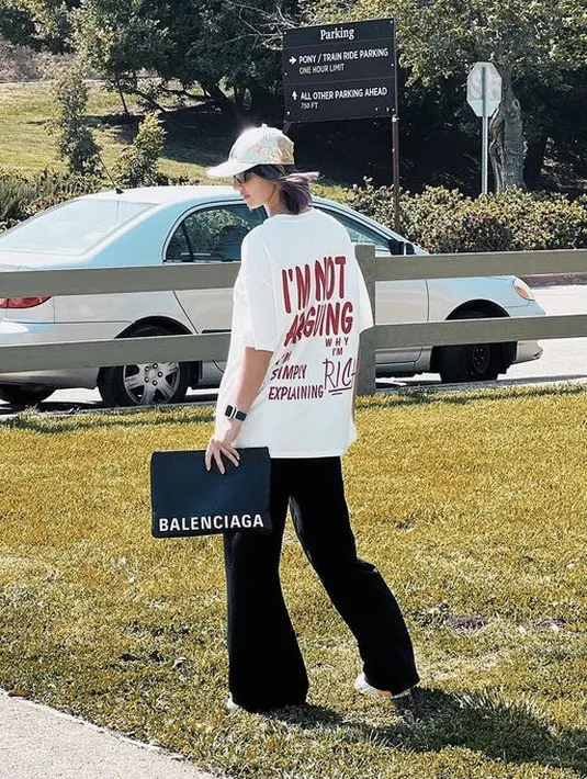 <p>Meski nampak belakang, Nia tampak keren dengan oversize tshirt putih dengan tulisan di belakangnya, dipadukan pallazo dan clutch hitamnya.&nbsp;@ramadhaniabakrie</p>