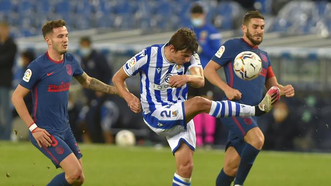 Gelandang Atletico Madrid, Saul Niguez, berebut bola dengan bek Real Sociedad, Robin Le Normand, pada laga lanjutan Liga Spanyol di Anoeta Stadium, Rabu (23/12/2020) dini hari WIB. Atletico Madrid menang 2-0 atas Real Sociedad. (AFP/Ander Gillenea)
