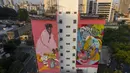 Mural raksasa karya seniman Heloisa Hariadne (kanan) dan Zeh Palito dipajang di dinding bangunan di Sao Paulo, pada 27 September 2021. Para seniman mural papan atas dikerahkan membuat lukisan raksasa karya terbaik mereka untuk berpartisipasi dalam festival selama seminggu. (AP Photo/Andre Penner)