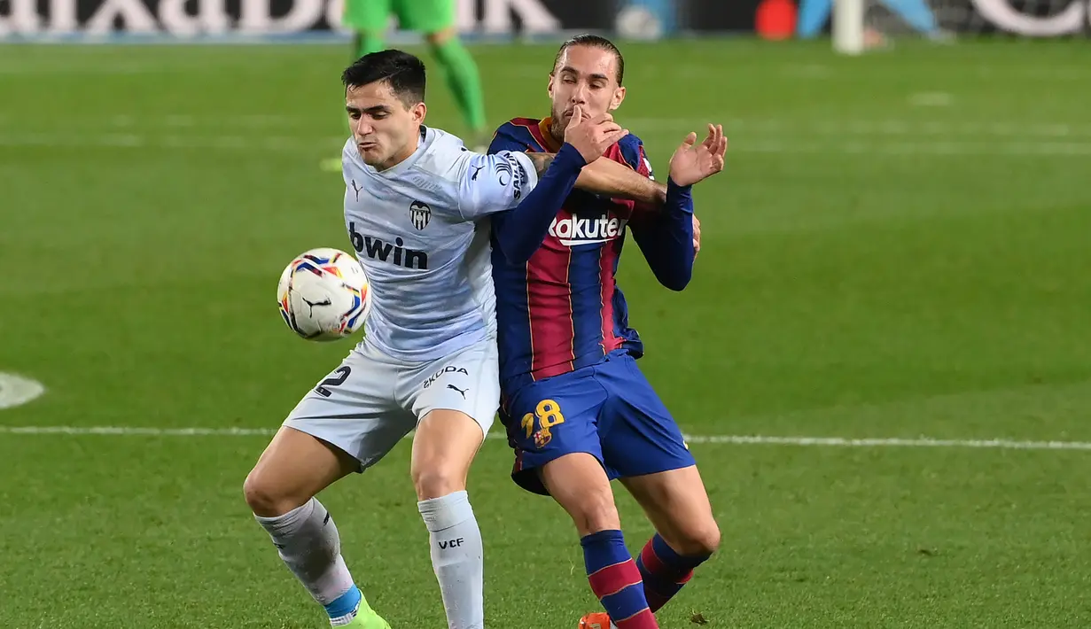 Striker Valencia, Maxi Gomez (kiri), berebut bola dengan bek Barcelona, Oscar Mingueza, dalam laga lanjutan Liga Spanyol 2020/21 di Camp Nou Stadium, Barcelona, Sabtu (19/12/2020). Valencia bermain imbang 2-2 dengan Barcelona. (AFP/Lluis Gene)