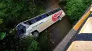 Gambar bus yang terjun ke sungai dangkal dekat Tegucigalpa, Honduras, Selasa (5/12/2023). Kecelakaan menewaskan 13 orang dan melukai puluhan lainnya. (Johny MAGALLANES/AFP)