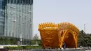 Seorang pekerja menyelesaikan pembangunan 'Golden Bridge Silk Road' di Beijing, China (18/4). Ada 28 kepala negara dan kepala pemerintahan yang akan menghadiri pertemuan yang digagas Presiden China Xi Jinping tersebut. (AP Photo/Andy Wong)