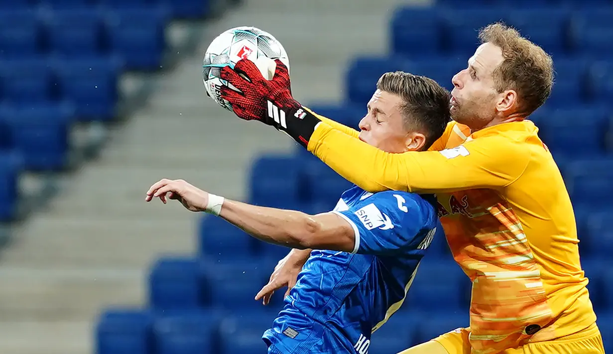 Kiper RB Leipzig, Peter Gulacsi, berebut bola dengan gelandang Hoffenheim, Christoph Baumgartner, pada laga lanjutan Bundesliga peka ke-30 di Rhein-Neckar Arena, Sabtu (13/6/2020) dini hari WIB. Leipzig menang 2-0 atas Hoffenheim. (AFP/Uwe Anspach/Pool)