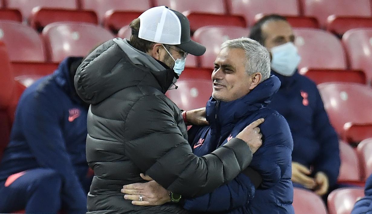 Manajer Liverpool, Jurgen Klopp (kiri) memeluk manajer Tottenham Hotspur, Jose Mourinho, sebelum dimulainya laga lanjutan Liga Inggris 2020/21 pekan ke-13 di Anfield Stadium, Rabu (16/12/2020). Liverpool menang 2-1 atas Tottenham. (AFP/Peter Powell/Pool)