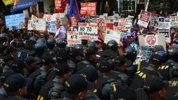 Polisi anti huru-hara berjaga saat unjuk rasa di depan kedutaan AS, Manila, Filipina (20/1). Ratusan warga Filipina berunjuk rasa jelang pelantikan Presiden terpilih AS, Donald Trump. (AFP Photo/Ted Aljibe)