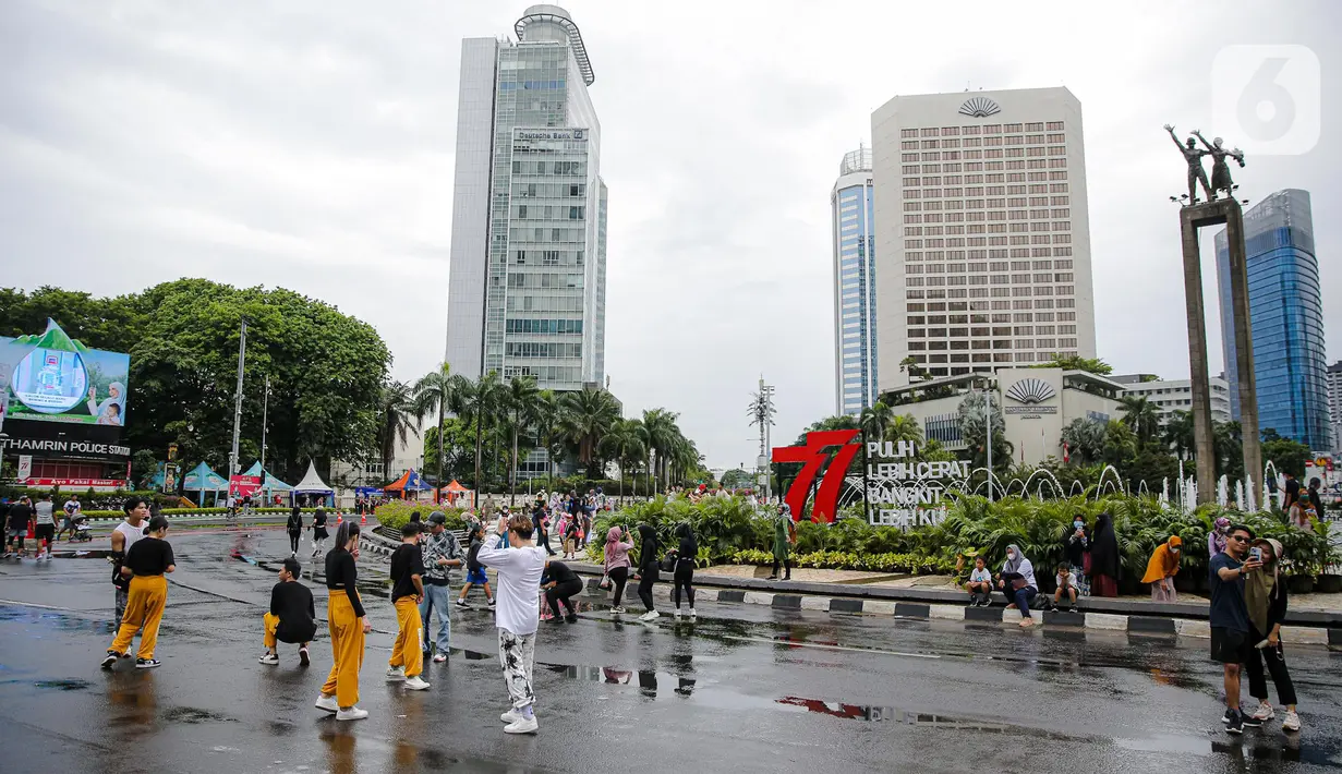 Suasana Car Free Day (CFD) di kawasan Bundaran HI, Jakarta, Minggu (2/10/2022). Meski diguyur hujan deras sejak pagi, warga tetap antusias untuk tetap berolahraga saat CFD. (Liputan6.com/Faizal Fanani)
