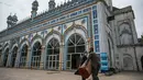 Umat Muslim melepas karpet sajadah dari aula utama masjid menyusul pembatasan baru pemerintah baru menjelang Ramadan di Rawalpindi, Pakistan, Senin (5/4/2021). Sesuai pedoman, warga juga diminta menghindari sholat di jalan atau trotoar dan melarang warga untuk berwudhu di masjid. (Aamir QURESHI/AFP)