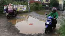 Kendaraan menghindari kubangan pada jalan yang rusak di Jalan Pertamina, Kemiri Muka, Depok, Jawa Barat, Selasa (5/3). Kondisi tersebut mengganggu aktivitas warga serta pengguna jalan. (Liputan6.com/Immanuel Antonius)