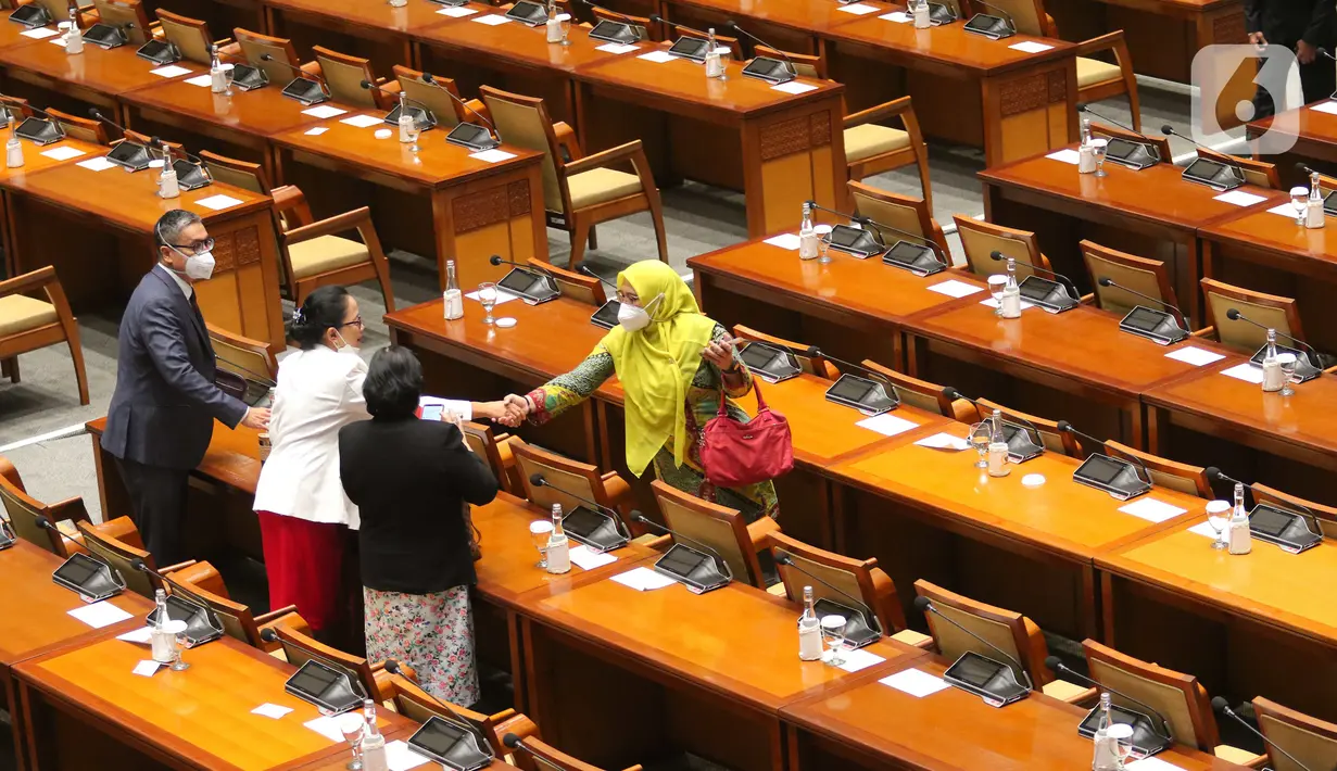 Anggota DPR RI bersalaman sebelum mengikuti pembukaan Rapat Paripurna Pembukaan Masa Persidangan V Tahun Sidang 2021-2022 di Nusantara II, Kompleks Parlemen MPR/DPR-DPD, Senayan, Jakarta, Selasa (17/5/2022). Rapat paripurna hari ini menandakan DPR kembali aktif bersidang setelah selesai menjalani masa reses. Hadir 76 anggota yang secara fisik, 252 secara virtual dan izin 5 anggota. Sehingga total kehadiran rapat paripurna hari ini adalah 333 dari 575 anggota DPR. (Liputan6.com/Angga Yuniar)