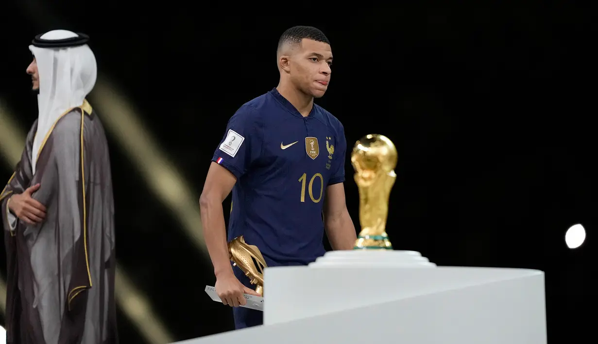 Ekspresi pemain Prancis Kylian Mbappe saat berjalan melewati trofi Piala Dunia 2022 usai melawan Argentina pada pertandingan final di Stadion Lusail, Lusail, Qatar, 18 Desember 2022. Argentina menang 4-2 dalam adu penalti melawan Prancis setelah pertandingan berakhir imbang 3 -3. (AP Photo/Martin Meissner)